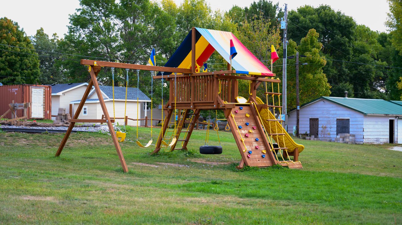 Wooden playground with swings and climbing wall at Twilight Cove